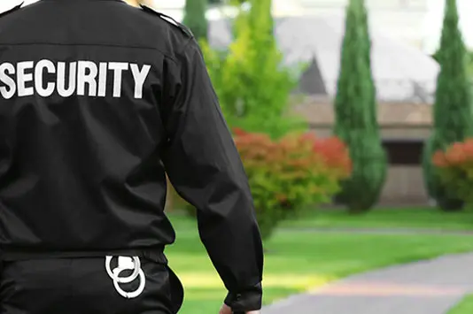 A security guard standing in front of a house.
