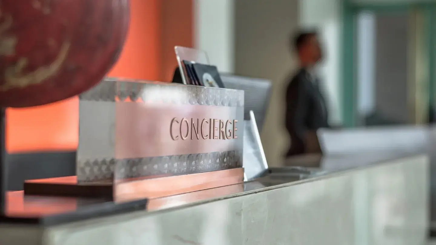 A concierge desk with a person in the background.
