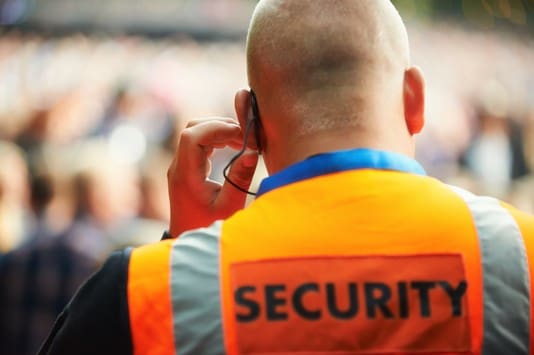 Rear view of a security guard listening to his headset